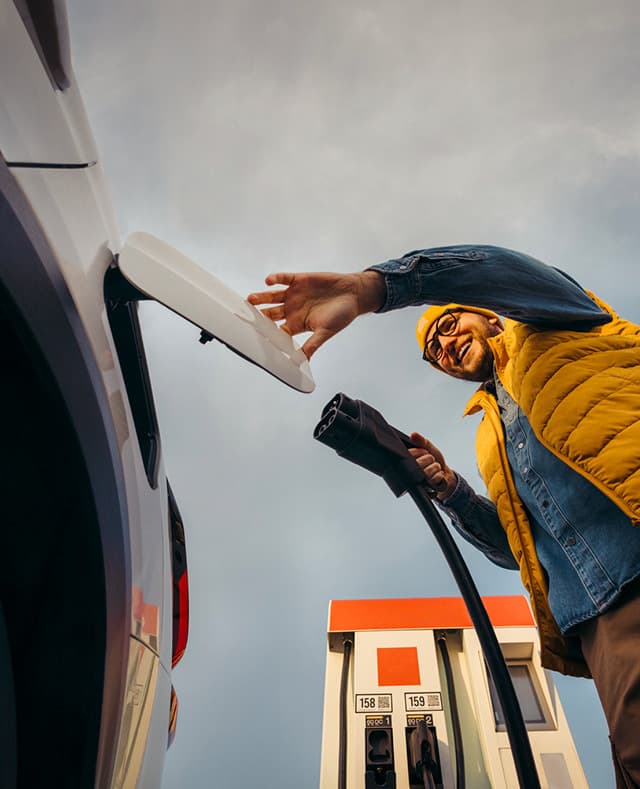 Man charging EV from the ground pov portrait
